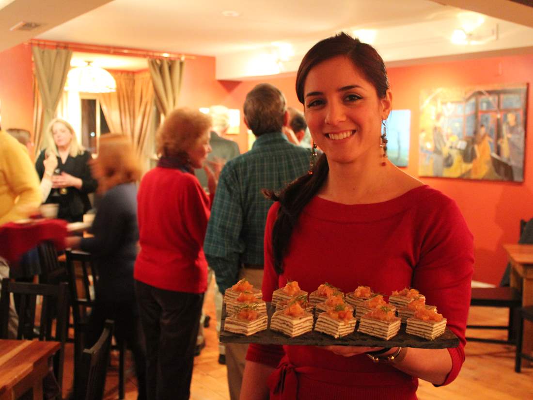 friendly Rustic Roots staff holding a tray of appetizers